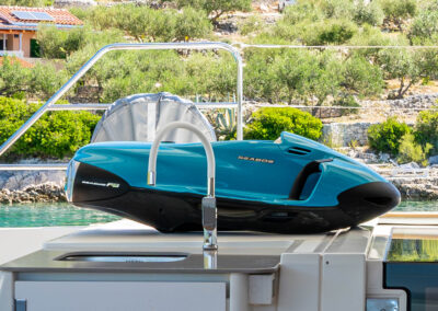 A blue Seabob F5 water scooter on the deck of a catamaran.